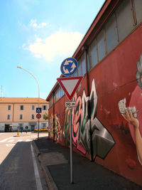 Graffiti on building against sky in city