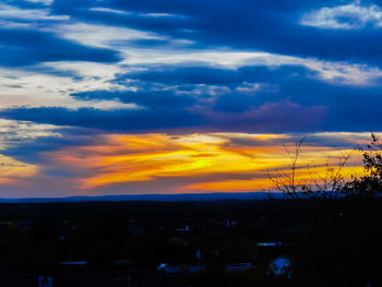 Silhouette landscape against dramatic sky during sunset