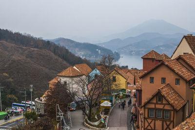 Street amidst buildings and mountains against sky