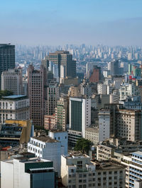 Aerial view of buildings in city against sky