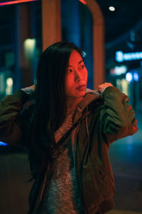 Woman looking away while standing at night