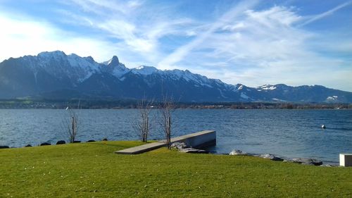 Scenic view of lake by mountains against sky