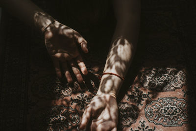 Cropped hands of woman on carpet
