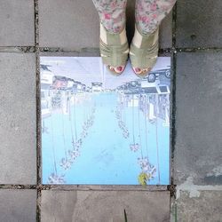 Low section of woman standing on tiled floor