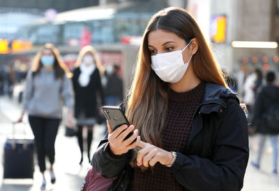 Young woman using mobile phone in city