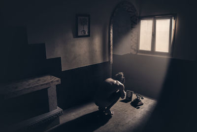 Shadow of man holding window in building