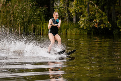 Full length of man splashing water in lake