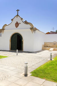 Footpath by church against clear sky