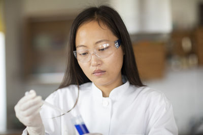 Scientist female with lab glasses and tubes in a lab