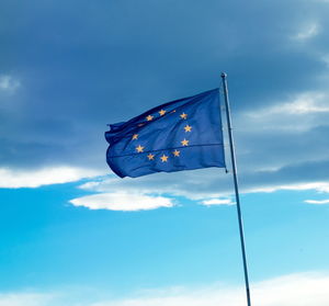 Low angle view of flag against blue sky