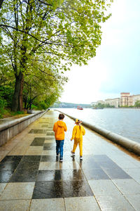 Rear view of people walking on footpath