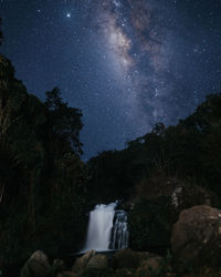 Scenic view of waterfall against sky at night