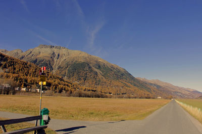 Road passing through landscape against blue sky