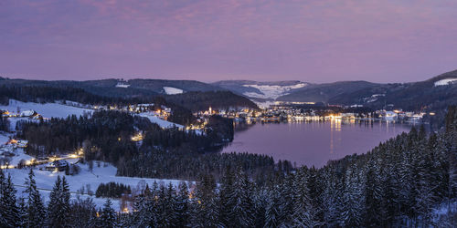 Scenic view of lake by mountains against sky during winter