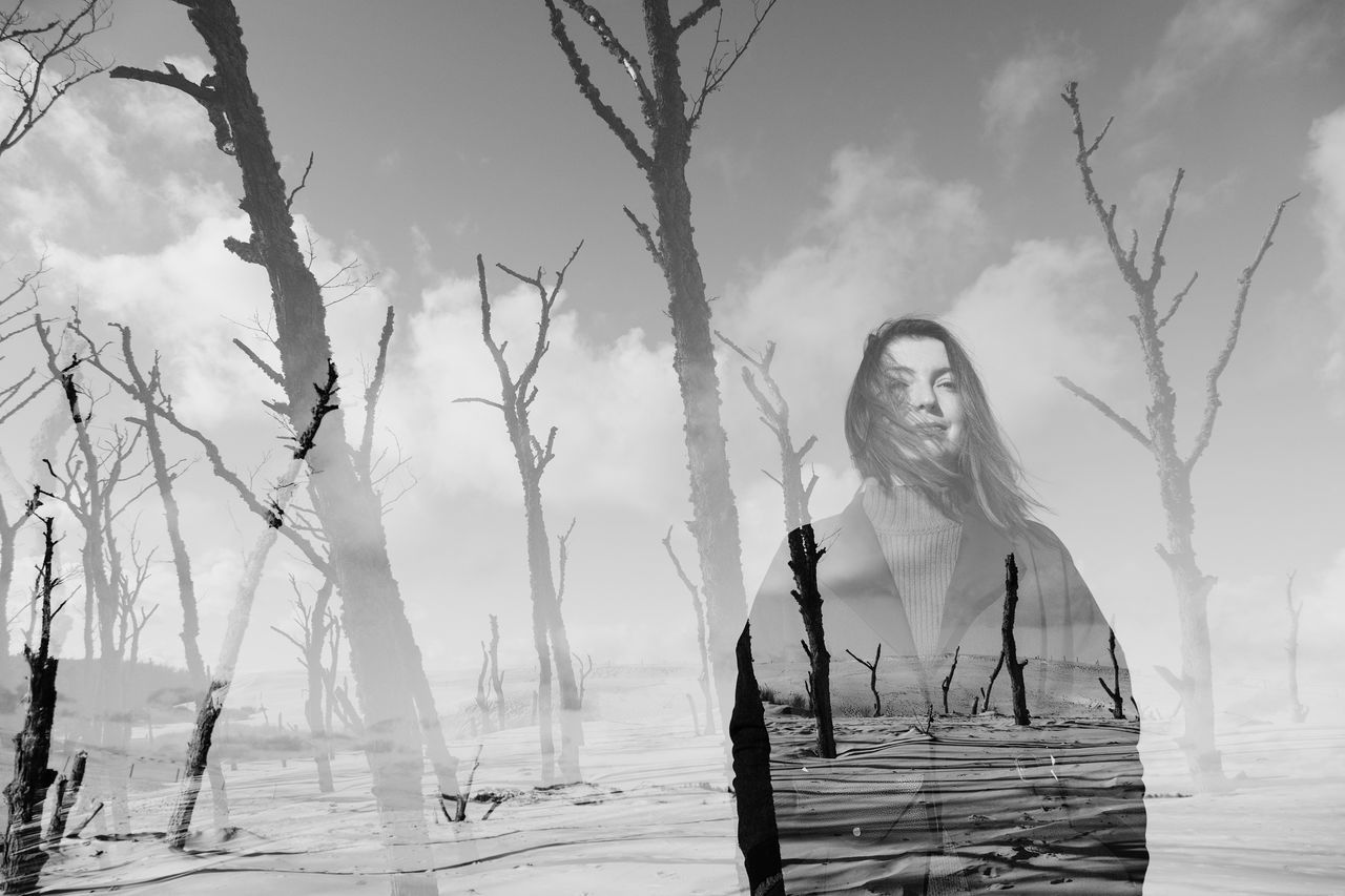 DIGITAL COMPOSITE IMAGE OF WOMAN STANDING AGAINST TREES