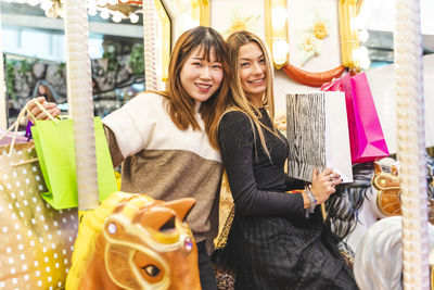 Couple of multiethnic young women having fun after shopping. concept of millennial generation