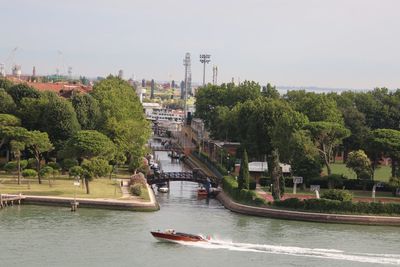 Boats in river with city in background