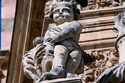 Low angle view of buddha statue against old building