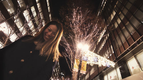 Woman standing against illuminated built structure