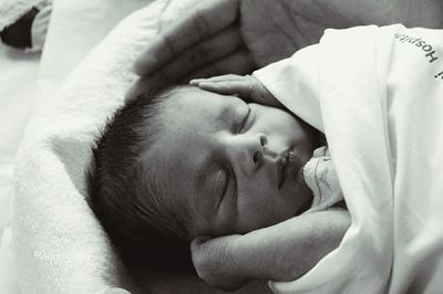 Close-up of baby girl sleeping on bed