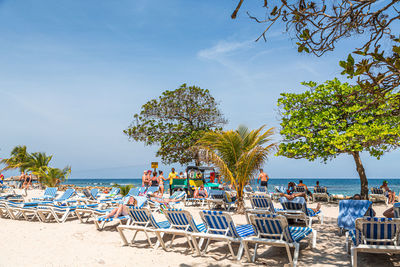 Chairs and table at beach against sky