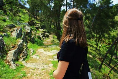 Side view of woman standing in forest