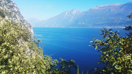 Scenic view of lake and mountains against blue sky