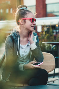 Young woman using mobile phone in restaurant