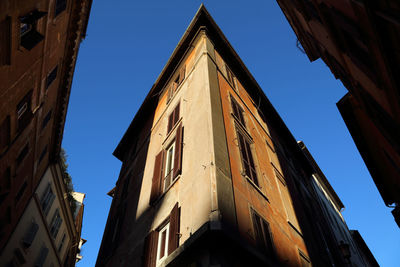 Low angle view of buildings against clear blue sky