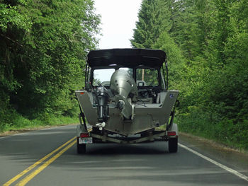 Car on road amidst trees in forest