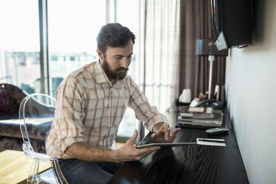 Businessman touching digital tablet in hotel room