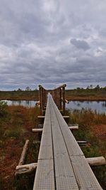 Pier over lake against sky