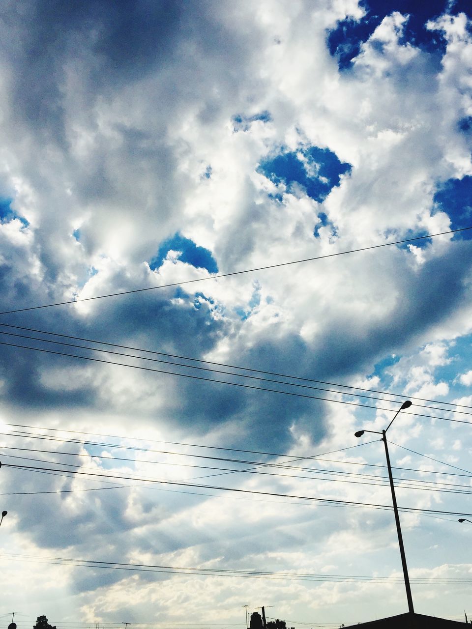 LOW ANGLE VIEW OF SILHOUETTE POWER CABLES AGAINST SKY