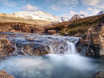 Scenic view of waterfall against sky