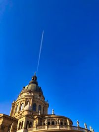 Low angle view of cathedral against blue sky and plane