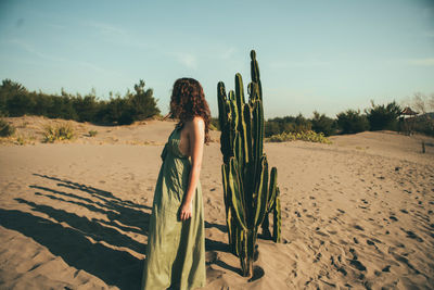 Woman standing on beach against sky
