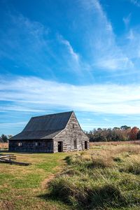 Old house on field against sky