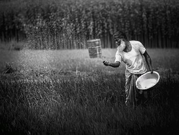 A farmer spreading fertilizer on the agricultural feed