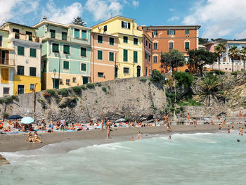 Group of people on beach against buildings in city