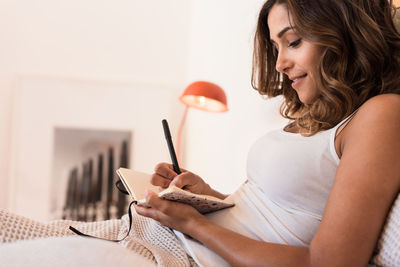 Young woman using mobile phone at home