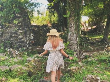 Rear view of woman standing by tree