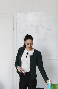 Businesswoman standing against whiteboard in office