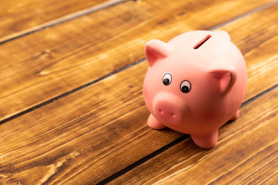 High angle view of piggy bank on wooden table