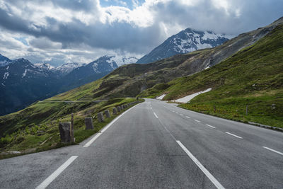 Road amidst green mountains against sky