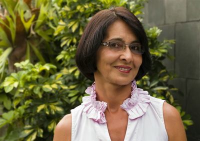 Close-up portrait of smiling woman against plants