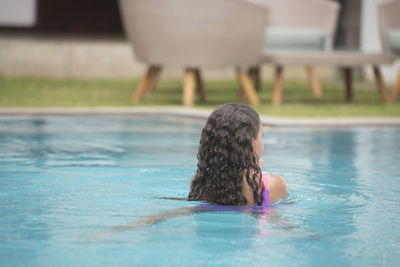 Rear view of woman swimming in pool