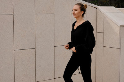 Woman jogging against wall