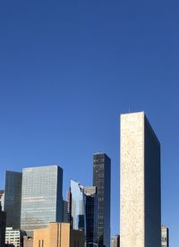 Low angle view of modern buildings against clear blue sky