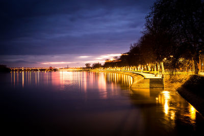 Bridge over river against sky at night