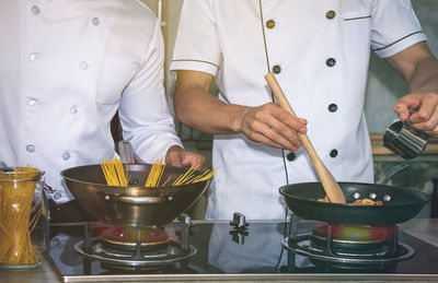 Midsection of man preparing food in kitchen